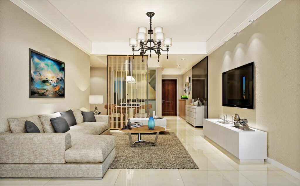 Neutral-toned living room interior with an L-shaped sofa, beige walls, elegant chandelier, and modern decor elements.
