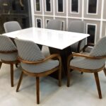 Contemporary quilted dining chairs with wooden armrests and legs, perfect for modern dining rooms.