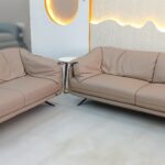 Premium leather sofa set with plush cushions and sleek metal legs in a modern living room setup.