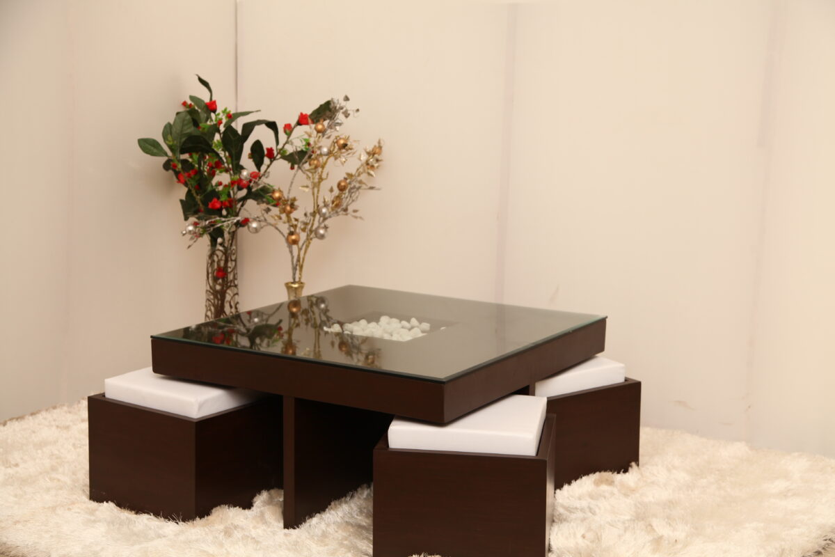 Modern glass-top center table with dark wooden base and 4 puffies, designed for compact living spaces