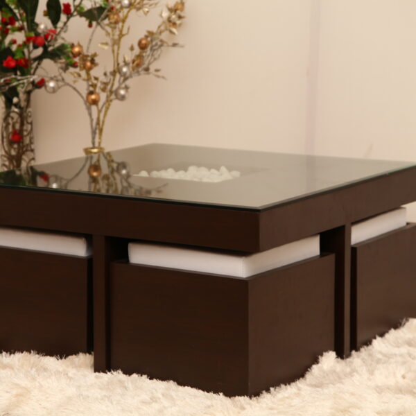 Modern glass-top center table with dark wooden base and 4 puffies, designed for compact living spaces.